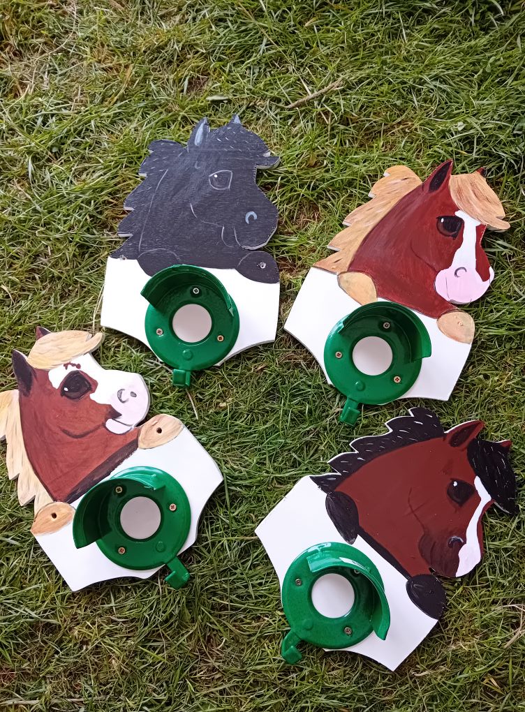 Four horse-shaped cutouts on grass with sash holder